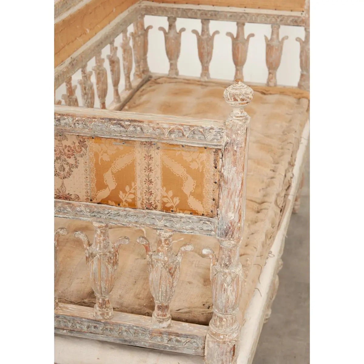 Slatted back entryway bench in natural wood, corner detail view of the carved upright and connecting rail.