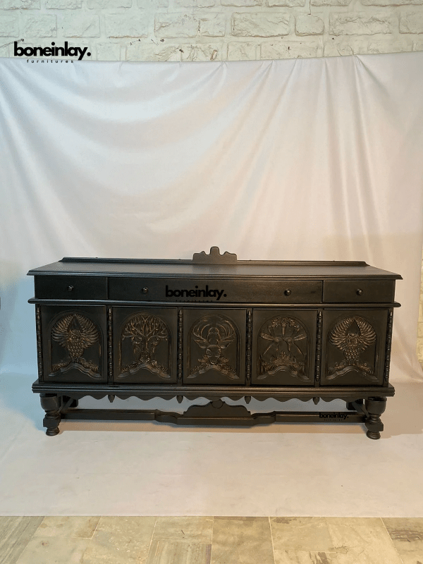 Black Wildlife Storage Credenza in wood, front view with carved animal doors and upper drawers against a fabric backdrop.
