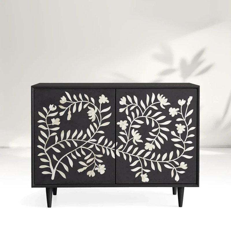 Bone inlay charcoal entryway cabinet with full-panel ivory floral motif, solid mango wood construction, styled in minimalist setting