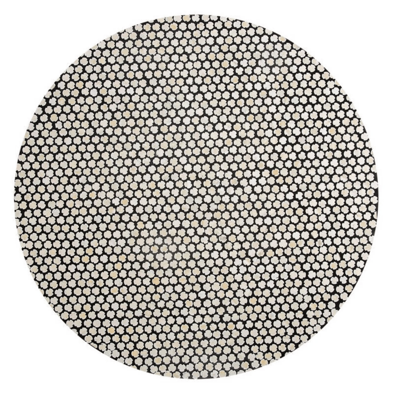 Overhead flat view of bone inlay coffee table surface with dense black and white clover polka dot pattern on solid wood