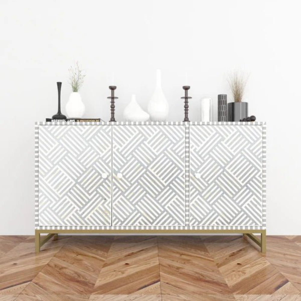 Bone inlay grey and white geometric pattern sideboard cabinet styled with white vases and candlesticks on herringbone wood floor in a bright room