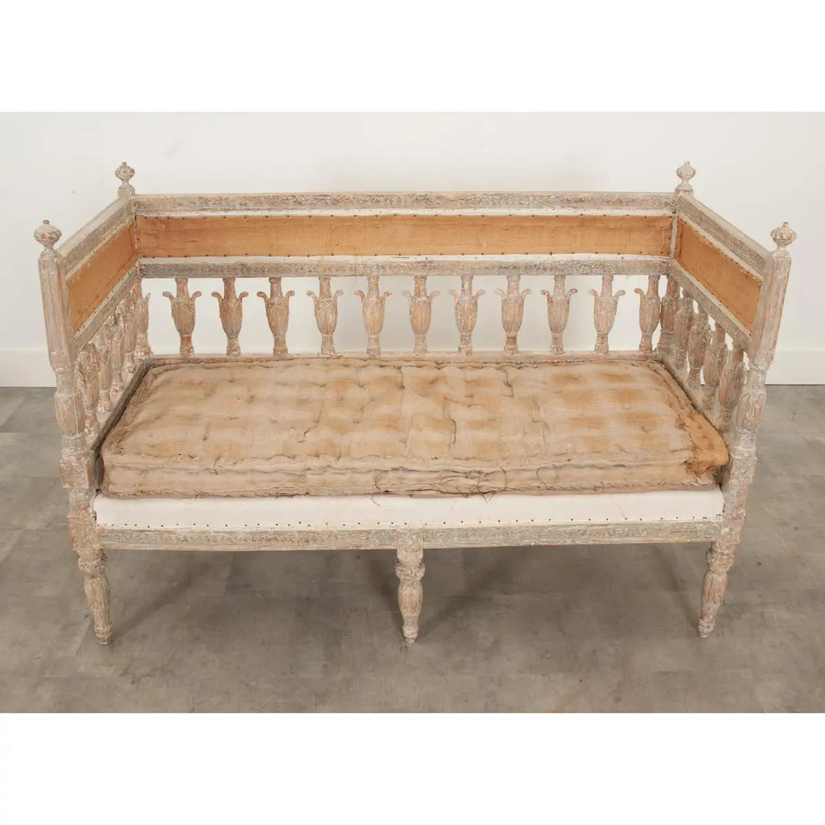 Classic slatted settee in pale wood with an upholstered seat, front view highlighting its tall back and turned legs.