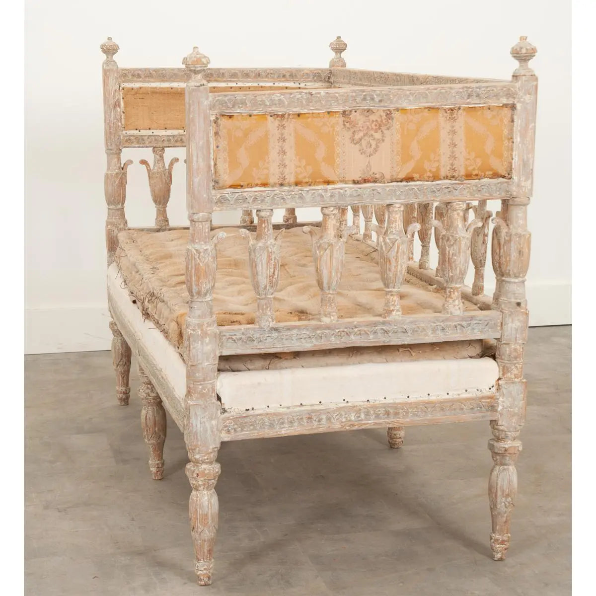 Cream upholstered dining bench in pale wood, front view showing the full cushioned seat and decorative slatted back.