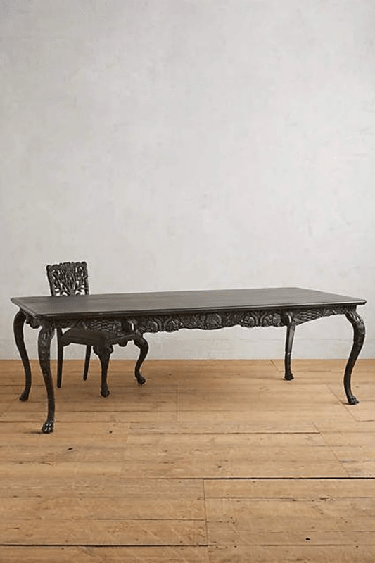 Ebony dining room table in solid wood, front view showing a dark rectangular tabletop above curved legs.