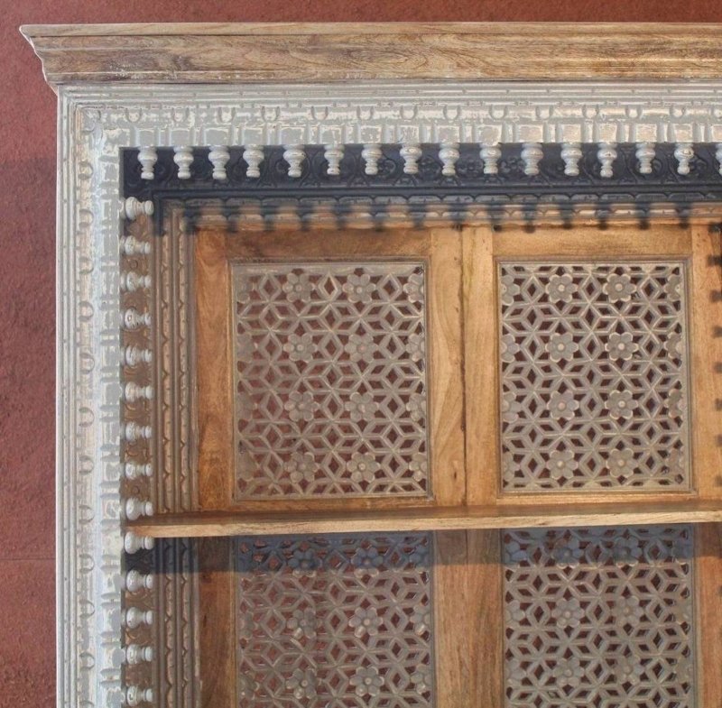 Geometric carved shelving unit in rustic wood, edge detail view showing decorative trim and star-pattern fretwork.