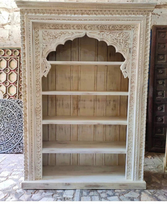 Hand-carved solid wood bookshelf in rustic whitewash, front view showing empty shelves and a scalloped arch.
