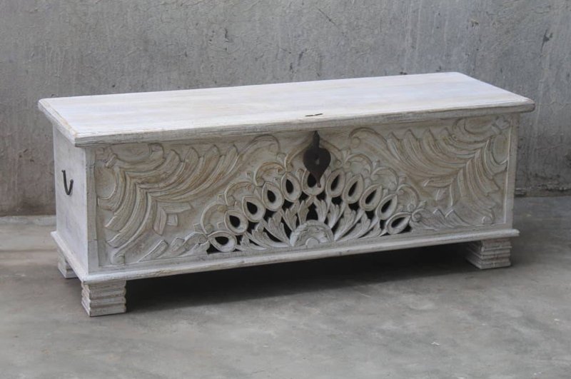 Hand-carved wood storage chest with a rustic finish, front view showing peacock cutouts, dark latch and block feet.