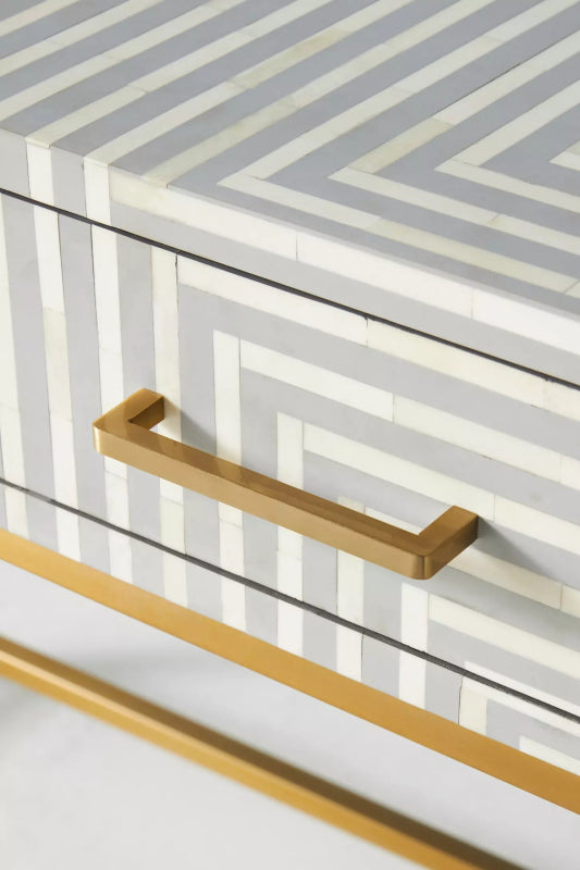 Close detail of handcrafted grey bone inlay console table drawer with brass bar handle and geometric striped pattern