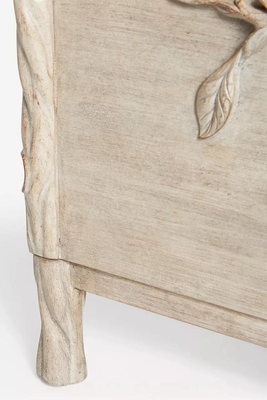 Close-up of the Ornithologie wood dresser showing its bird-and-foliage carving and tree-trunk-style legs.