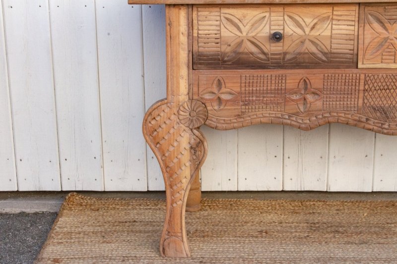 Sculpted Wood Hallway Table in a rustic finish, close-up of leg showing textured carving and a floral shoulder detail.