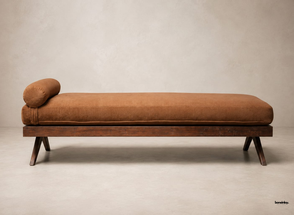 Handmade wooden daybed featuring a rich dark wood finish, angled legs, and a thick brown upholstered mattress with an attached bolster pillow. This artisan lounge piece brings mid-century modern style and comfortable seating to luxury US living rooms.