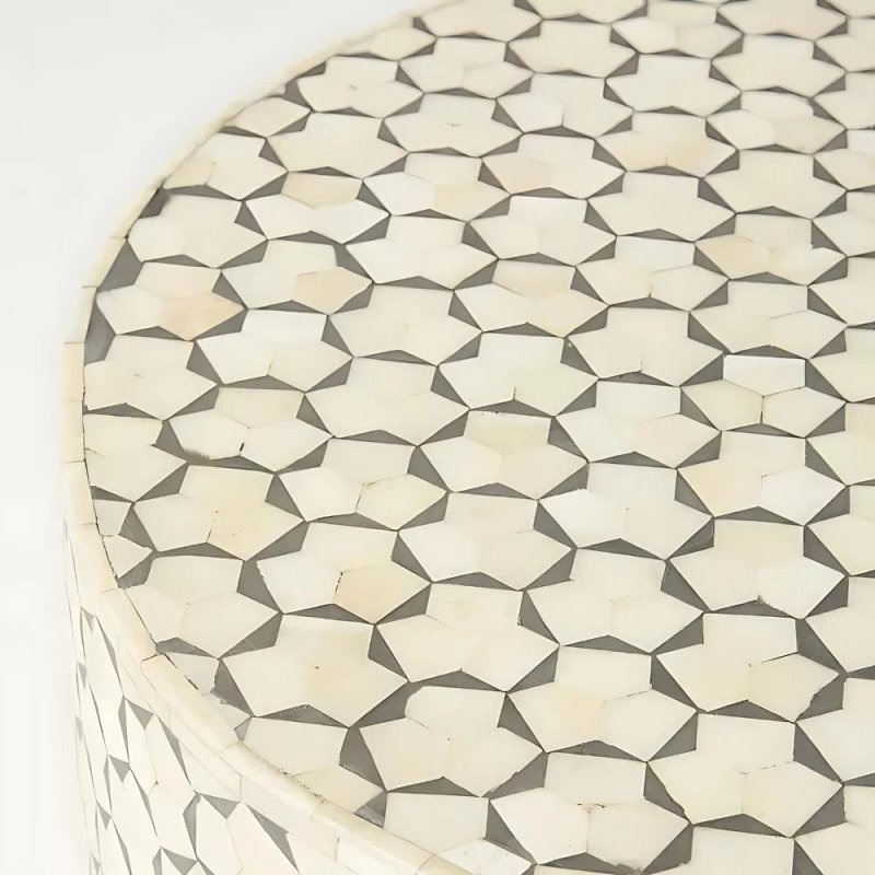 White bone inlay oval coffee table with geometric pattern and brass base, close-up view of the carved inlay surface