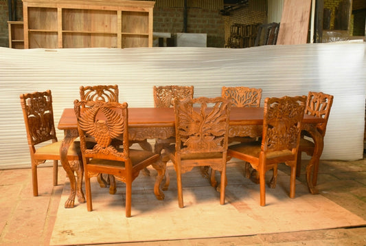 Wildlife carved dinette set in warm natural wood, front view with an owl chair back, leafy carvings and sculpted table legs.