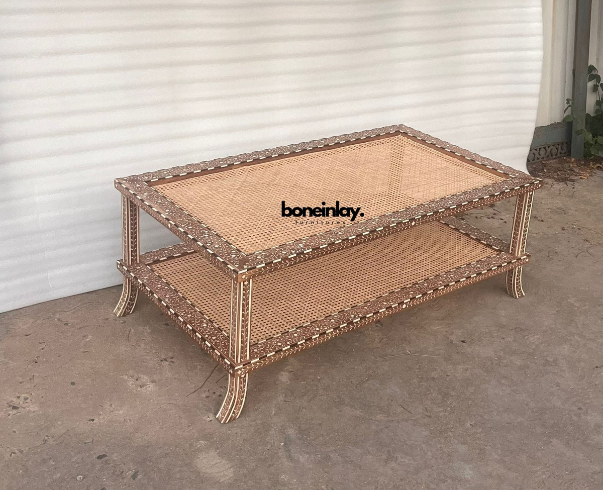 Rectangular two-tier wooden coffee table featuring floral bone inlay borders, natural woven rattan cane shelves, and curved legs.