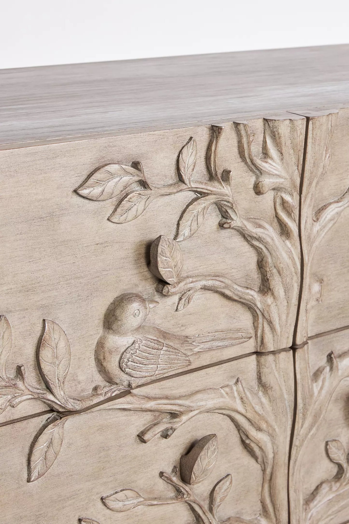 Brass ring pull hardware on hand-carved Ornithology solid wood drawer dresser