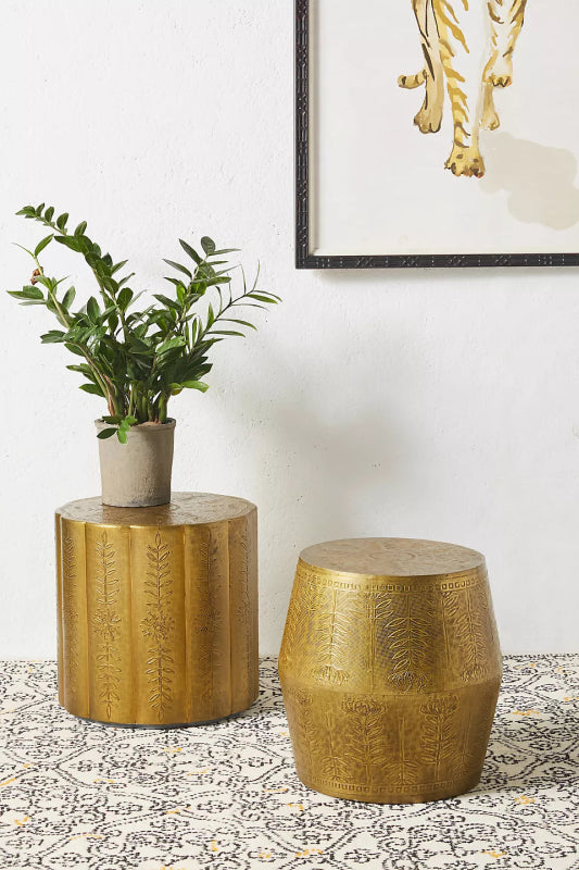 Eclectic embossed metal table with round top, ideal for displaying books, drinks, or a houseplant.