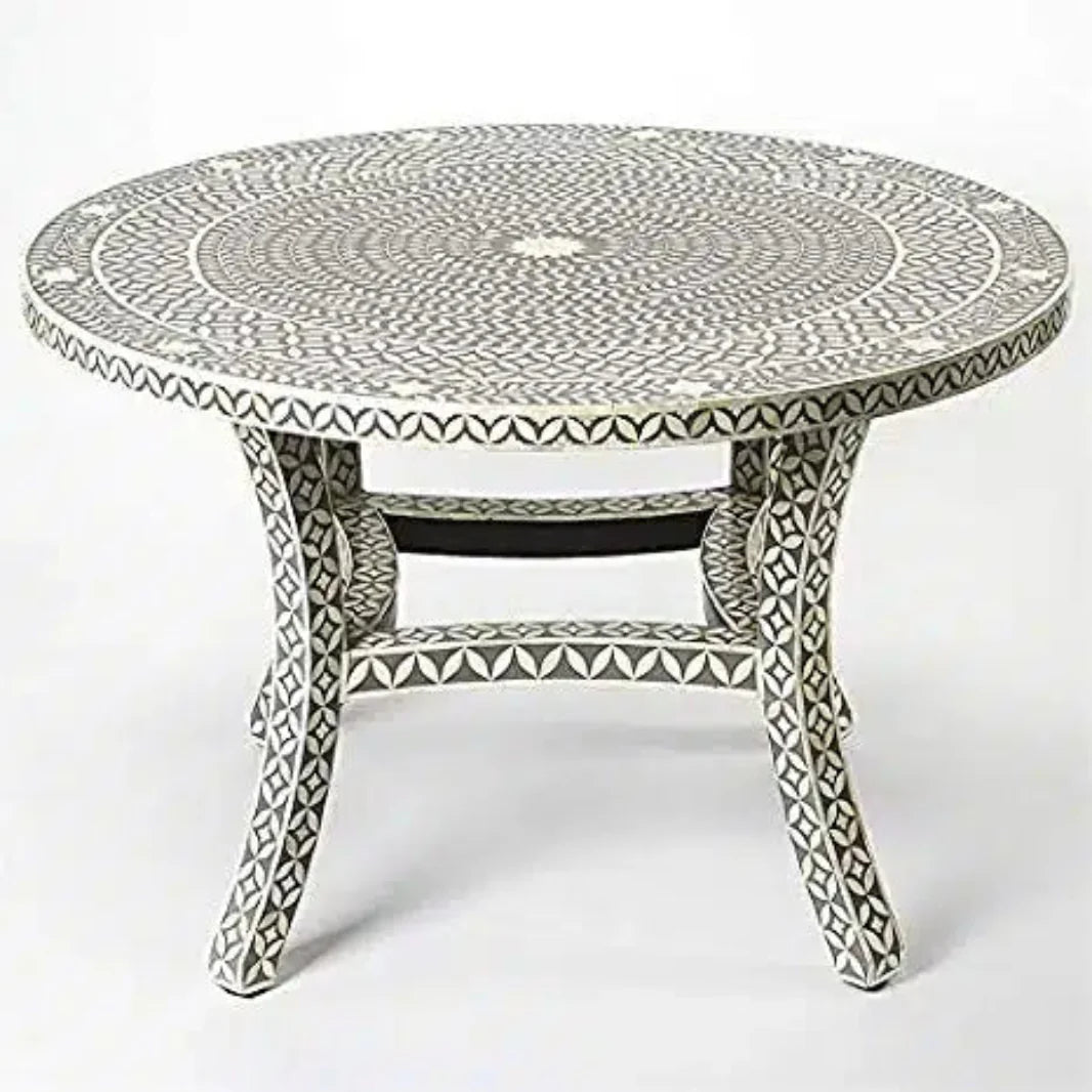 Angled view of a round gray bone inlay dining table showing its concentric leaf-patterned top and ivory-inlaid curved legs.