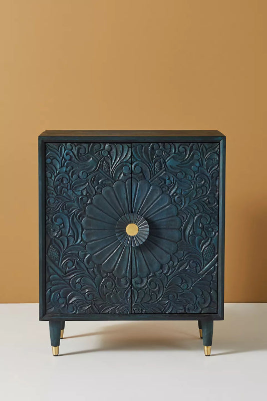 Gulliver cabinet in a deep-teal stained finish, featuring an expansive, hand-carved swirling floral pattern with a prominent central gold-tone medallion and gold-capped tapered legs.