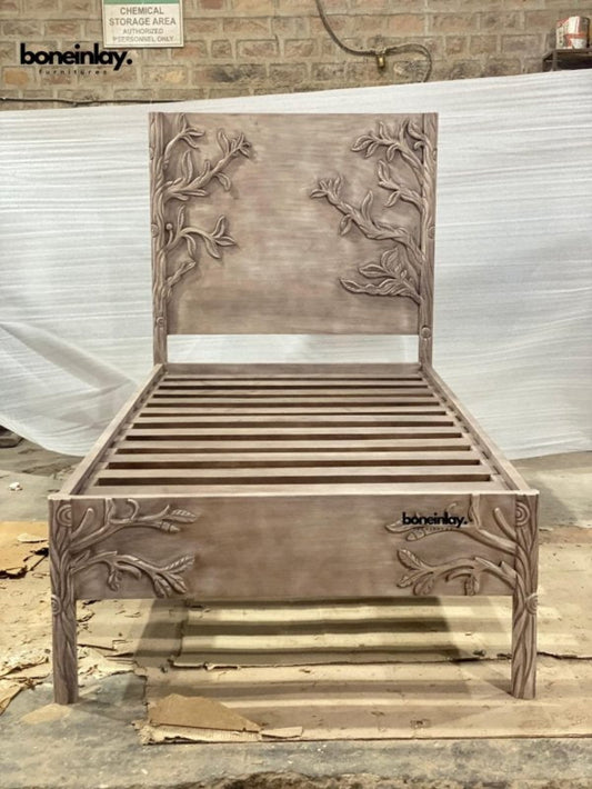 Hand-carved mango wood twin bed frame with branch and leaf details and a natural sand-wash finish