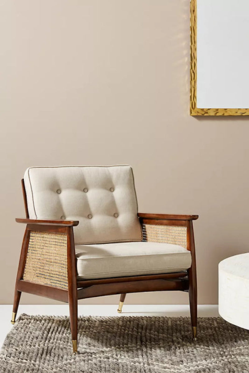 Handcrafted mid-century modern accent lounge chair with solid walnut wood frame, natural rattan woven side panels, tufted cream linen cushion and brass capped legs