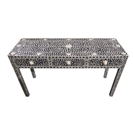 Elevated view of a black bone inlay console table with all-over floral inlay on drawers and legs, bone flower knobs, handmade on mango wood frame, white background.