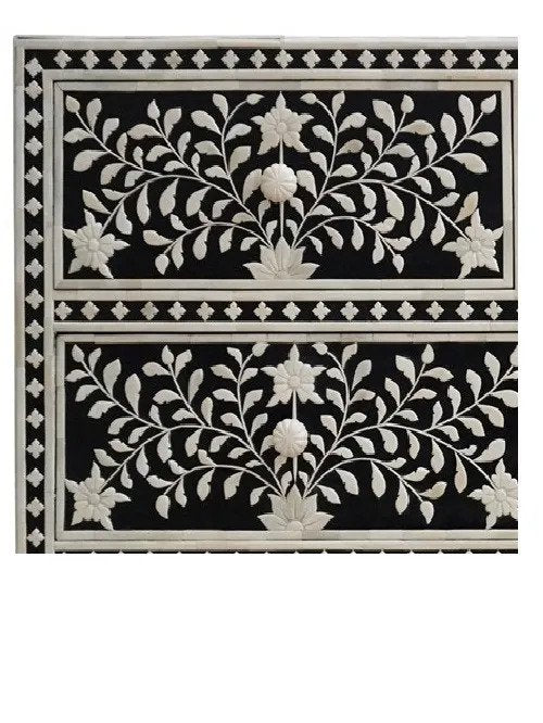 Close detail of ivory bone inlay botanical floral motif on black dresser drawer panels with star border and round jewel knob inlay work