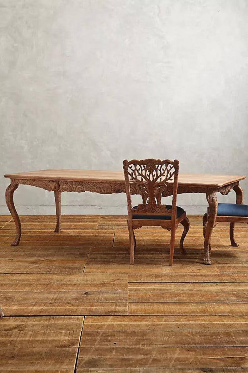 Hand carved menagerie natural dining table in warm solid wood, front view showing a rectangular top and sculpted curved legs.