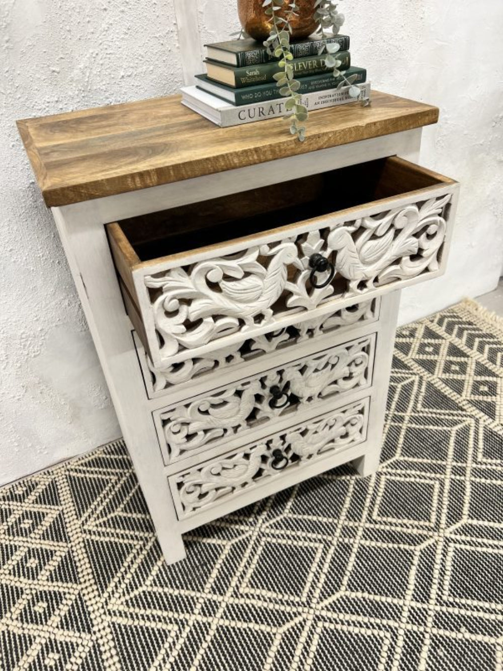 Peacock four-drawer bureau in rustic mango wood, open drawer view showing the wooden interior beneath a brown top.