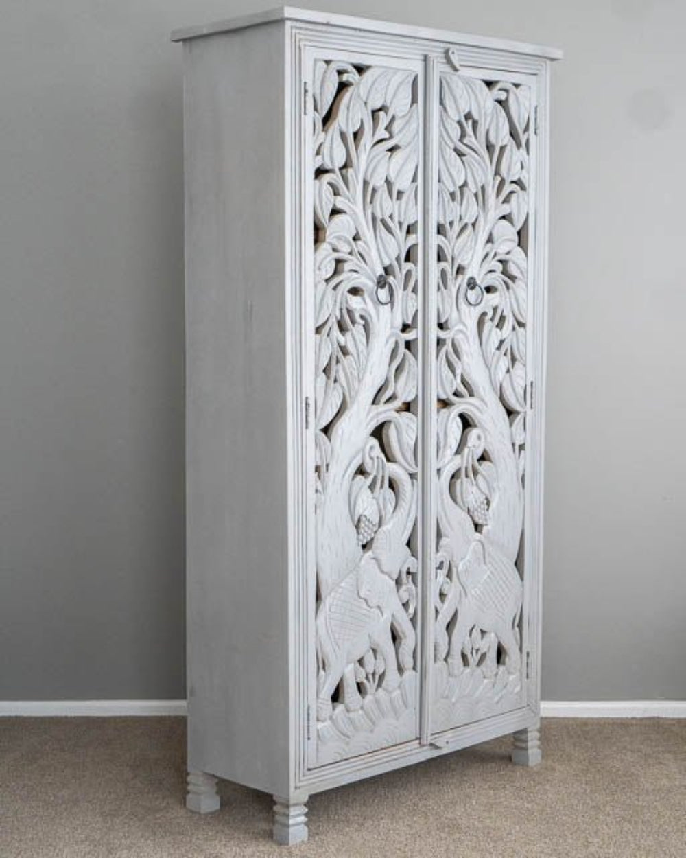 White Hand-Carved Wardrobe in a three-quarter view, showing the cabinet depth, arched doors, and carved jungle design.