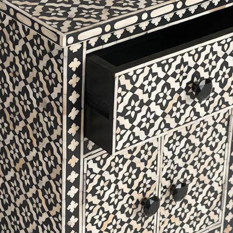 Open drawer detail of black and white bone inlay geometric bedside cabinet showing inlay pattern on drawer front and side panel