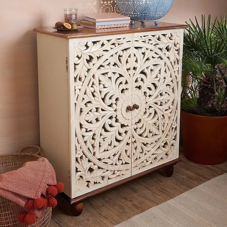 Hand-carved solid wood cabinet with an intricate white-washed floral medallion design on the cabinet doors and a contrasting natural wood top.