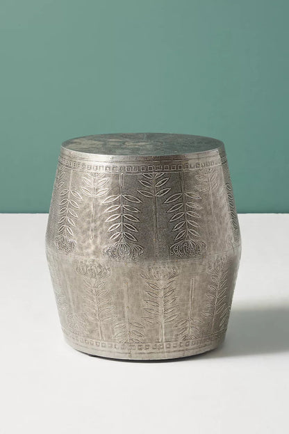  Embossed metal drum stool featuring an antique silver foil cladding with a hand-etched botanical pattern of blooming flowers and vines.
