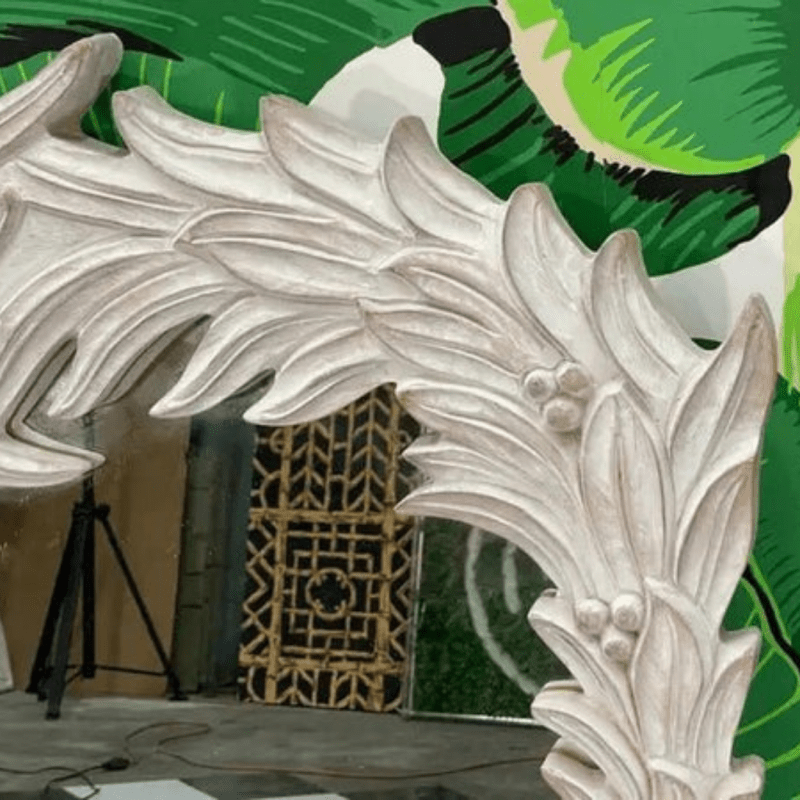 Acanthus wood looking glass in a rustic finish, corner detail view showing deeply carved leaves and rounded buds.