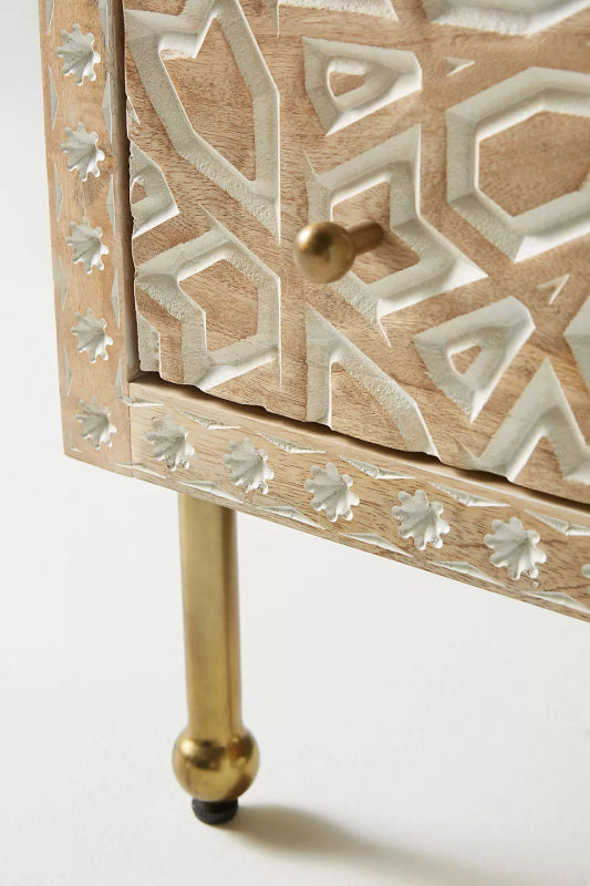 Albaron Geometric Carved Wood bedside with a brass leg, close-up showing the lower drawer corner, knob, and patterned border.