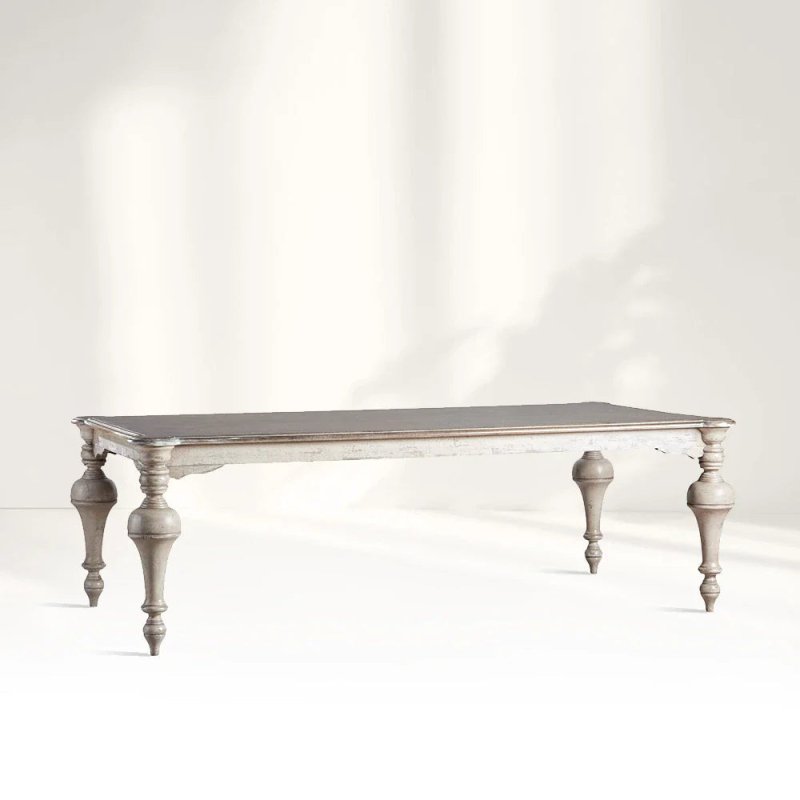 A large French Provincial style solid wood dining table with ornate hand-turned baluster legs and a distressed white-wash finish.