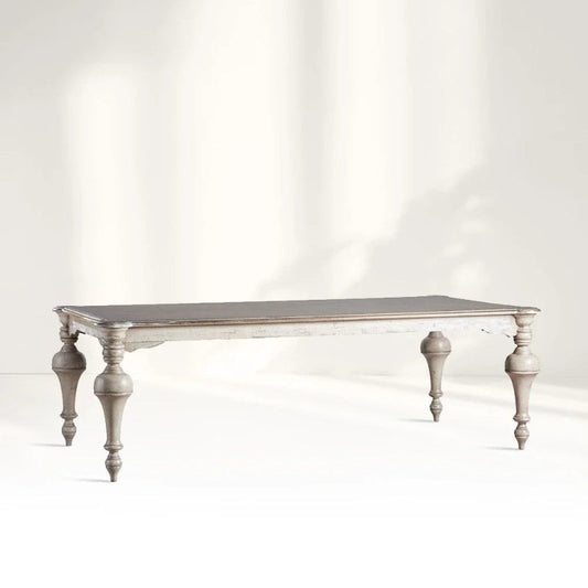 A large French Provincial style solid wood dining table with ornate hand-turned baluster legs and a distressed white-wash finish.