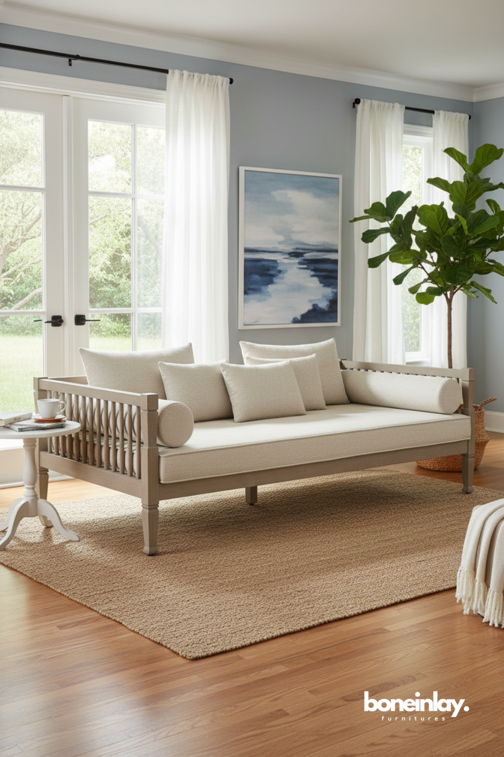 Spindle-style daybed with neutral cushions styled in a light and airy living room.