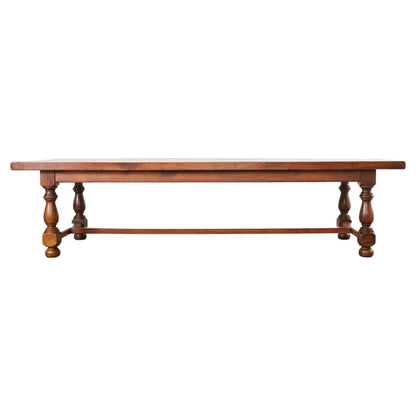 Grand English Elizabethan style dining table featuring hand-carved bulbous trestle legs and a rich dark oak finish.