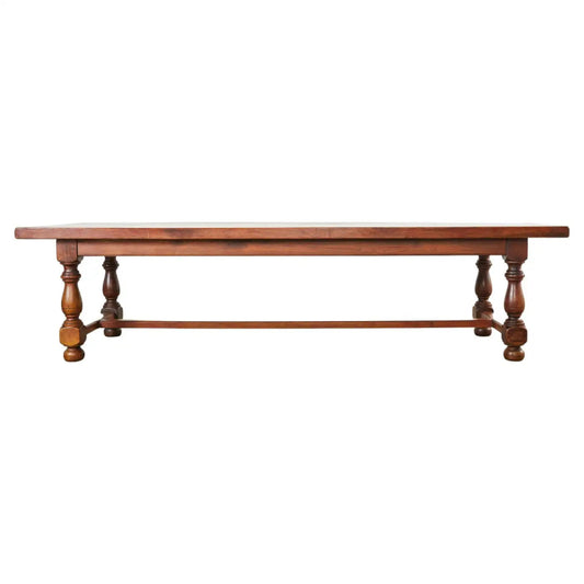 Grand English Elizabethan style dining table featuring hand-carved bulbous trestle legs and a rich dark oak finish.