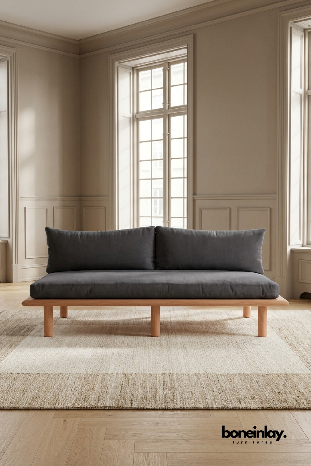 Minimalist wooden platform sofa with charcoal gray upholstered cushions, modern contemporary seating featuring clean Scandinavian-inspired design.