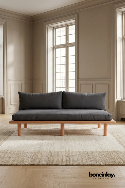 Minimalist wooden platform sofa with charcoal gray upholstered cushions, modern contemporary seating featuring clean Scandinavian-inspired design.