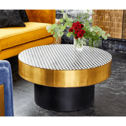 Three-quarter front view of a round bone inlay coffee table with a black and white diamond checkerboard top, gold metal rim, and black pedestal base, presenting the geometric tabletop and cylindrical support against a light background.