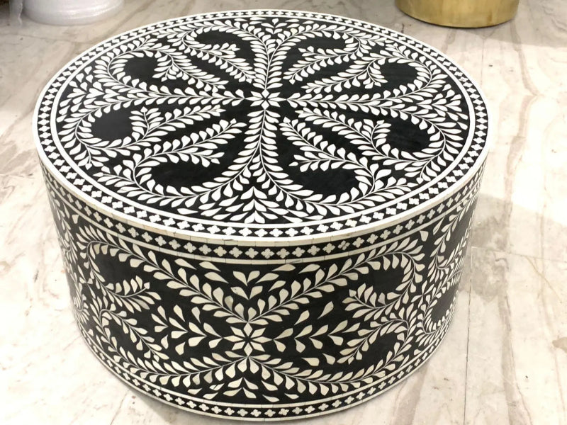 Artisan-crafted black and white bone inlay round drum table showing handcrafted floral vine mosaic on full cylindrical body and all-over leaf and medallion pattern on tabletop.