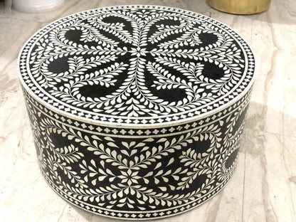 Artisan-crafted black and white bone inlay round drum table showing handcrafted floral vine mosaic on full cylindrical body and all-over leaf and medallion pattern on tabletop.
