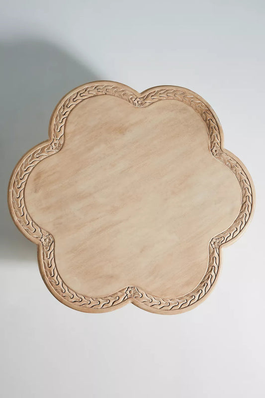 Top of the hand-chiseled border detailing on an artisan carved solid wood accent table with a soft scalloped rim