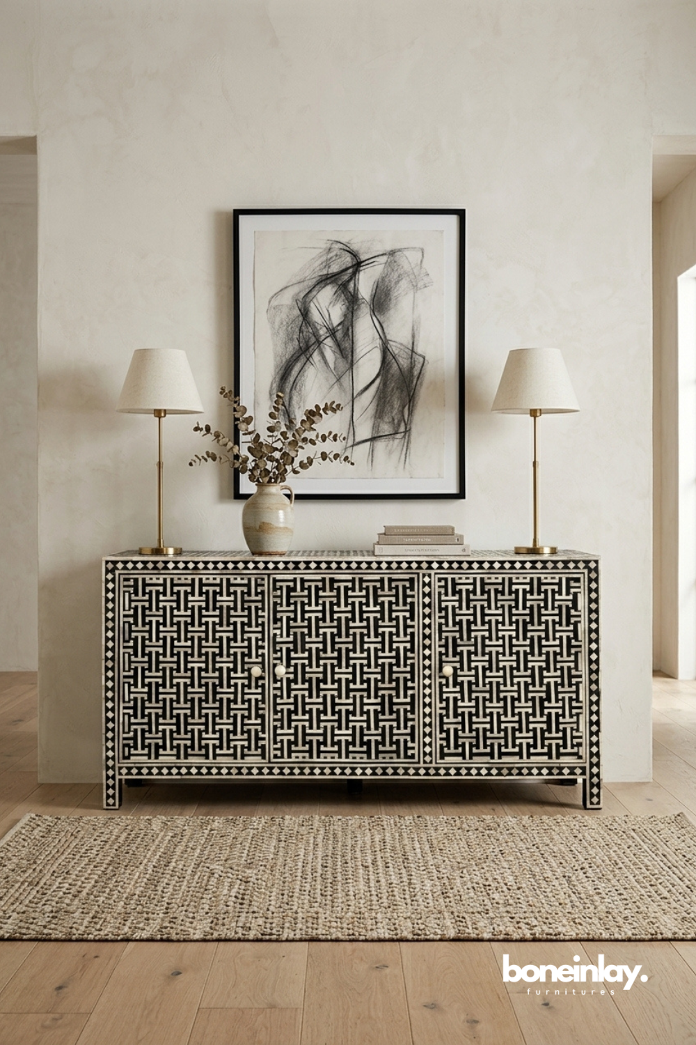 Artisan crafted black and white basket weave bone inlay sideboard cabinet styled in a luxury neutral entryway with brass lamps, dried botanicals, and abstract framed art.