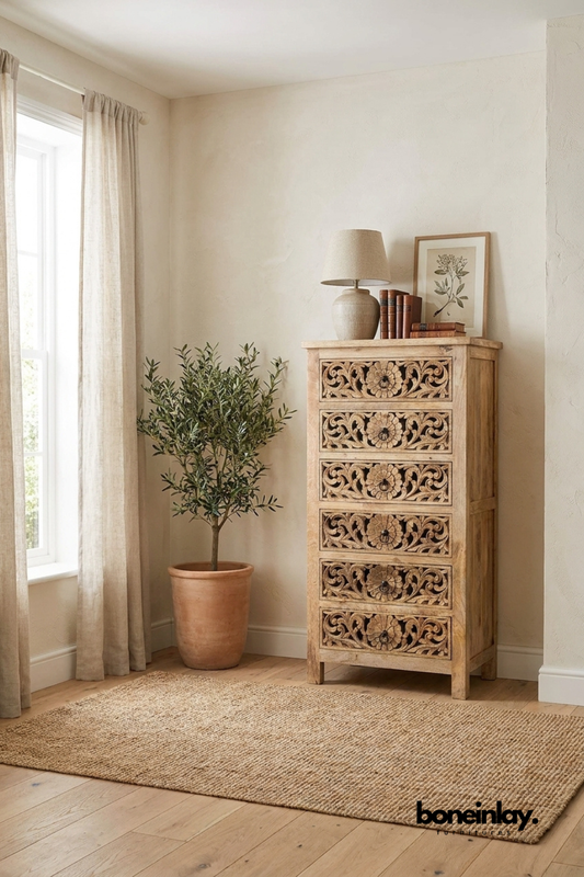 Natural wood tall chest with six hand-carved floral drawer fronts.
Detailed flower and vine carving repeats down each drawer panel.
Slim silhouette suits narrow bedroom or hallway spaces.
Styled beside a terracotta planter and framed botanical print.