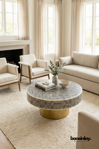 Handcrafted round bone inlay coffee table with black and white geometric cube pattern and gold brass pedestal base on white background