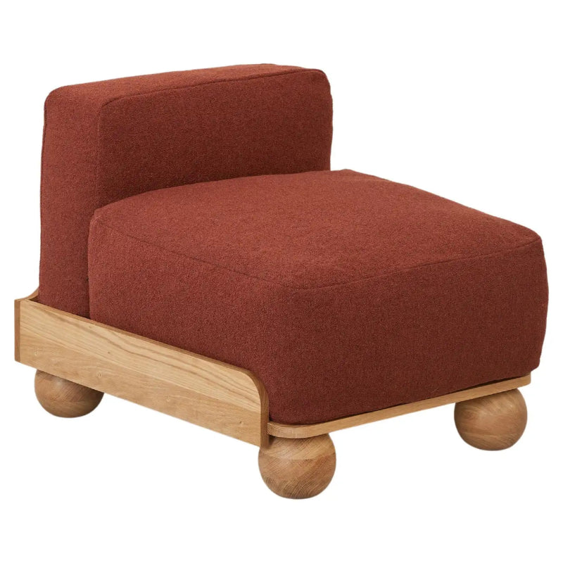 Modern armless accent chair with rust red upholstered seat, sculptural wooden base and contemporary minimalist design for living room interiors.