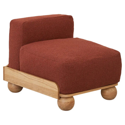 Modern armless accent chair with rust red upholstered seat, sculptural wooden base and contemporary minimalist design for living room interiors.